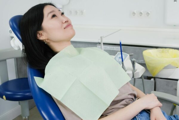 A young woman sitting calmly and comfortably in a dental chair at Spray Lake Dental in Cochrane, illustrating a stress-free dental experience.