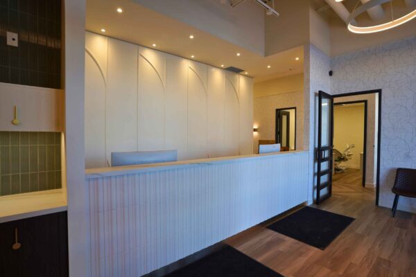 Patient Coordination Desk at Spray Lake Dental Our professional patient coordination desk in Cochrane, showcasing modern architectural arched details and a clean atmosphere.
